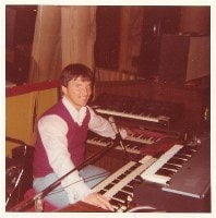 Dan performing at keyboards on the road, 1976